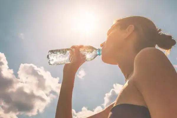 Hydration: The Secret Ingredient for a Toned Stomach and Enhanced Fitness 3 Image of woman drinking water to hydrate Stowmarket after run.