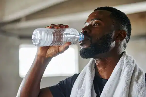 Hydration: The Secret Ingredient for a Toned Stomach and Enhanced Fitness 1 Image of man drinking water to improve hydration Stowmarket after work out.